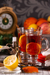 Two glasses with mulled wine on a tray with christmas accessories