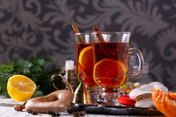 Two glasses with mulled wine on a tray with christmas accessories