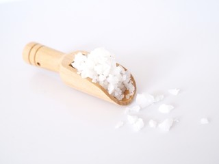 Fototapeta na wymiar Sea salt in wooden scoop isolated on white background.