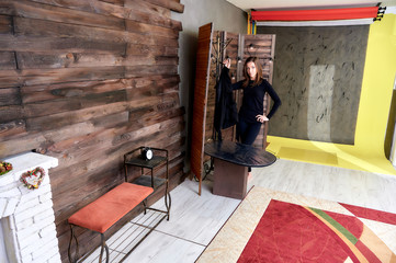 Studio portrait. Photo in a stylish interior in the studio of a pretty glamorous brunette, a girl in a black T-shirt with long hair on a color alternative fashionable original background.