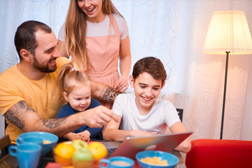 Fototapeta na wymiar friendly caucasian family together in kitchen at home, spend leisure time while having breakfast or launch, happy children and parents indoors