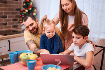 careful parents and beautiful kids spend time together at home, have breakfast, have meal at home in kitchen