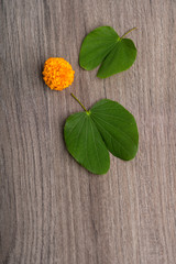 Indian Festival Dussehra, showing golden leaf (Bauhinia racemosa) and marigold flowers on a wooden...