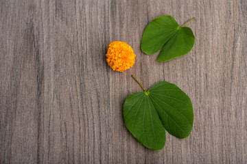 Indian Festival Dussehra, showing golden leaf (Bauhinia racemosa) and marigold flowers on a wooden...