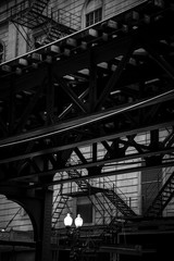 L-train railway line pass by a building with fire escape staircase, Chicago, Illinois, USA