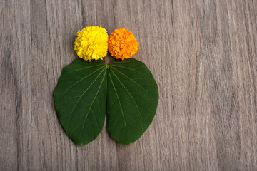Indian Festival Dussehra, showing golden leaf (Bauhinia racemosa) and marigold flowers on a wooden...