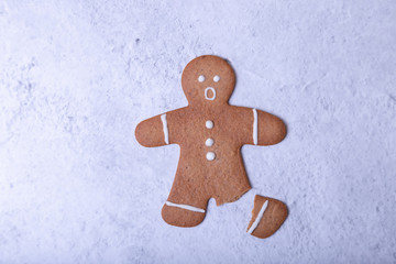 Gingerbread man with a broken leg (without leg) and with a surprised face. Traditional New Year and...