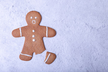 Gingerbread man with a broken leg (without leg) and with a surprised face. Traditional New Year and...