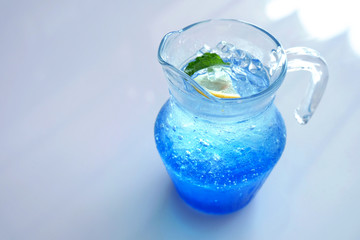 Iced Italian blue soda served in a jug on white background