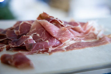 Sliced ham on wooden background. Fresh prosciutto. Pork ham sliced.