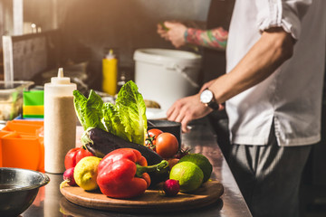Professional chef cooking in the kitchen restaurant at the hotel, preparing dinner. A cook in an...