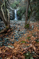 Waterfall splashing in the canyon in autumn.