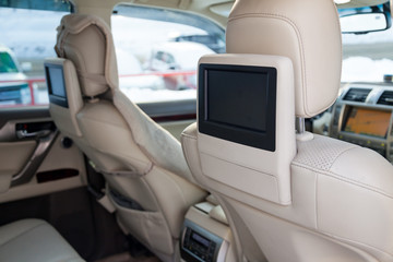 Entertainment system for rear passengers in a car with two monitors mounted on the backs of the...
