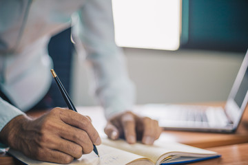 Businessman making notes on the paper in his office