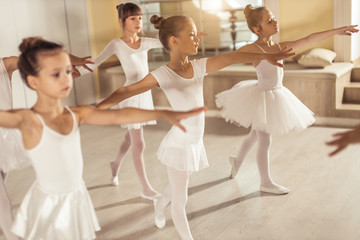 sweet caucasian little ballerinas wearing white tutu perdorming dance together, ballet concept