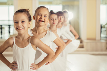 pretty beautiful ballerinas girls ready to perform classic dance ballet on stage, kids dressed in white tutu skirts, stand together, group dance