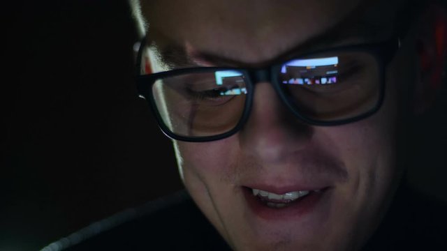 Man watching nude content online on smartphone in reflection of glasses