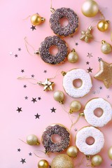 Obraz na płótnie Canvas Top view of christmas composition decoration of snowflakes, stars, confetti, balls, golden and white donuts on a pink background. Christmas and New Year happy holiday concept. Flat lay.