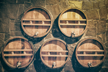 wooden wine barrels in stone wall