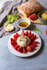 Italian style appetizer: burrata cheese and tomatoes with olive oil, balsamic oil and fresh ciabatta