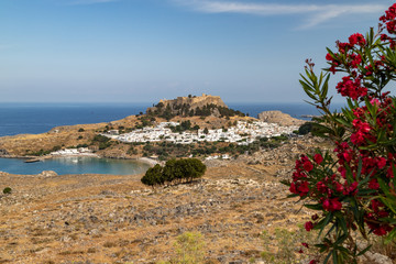 Scenic view at the city of Lindos with white houses, the antique Acropolis on top of the mountain,...