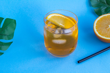 Aperol spritz cocktail or orange cocktail in the  glass on the tropical background. Copy space.