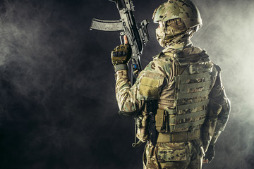 young soldier of russian military forces stand in smoky foggy space holding gun rifle, wearing...