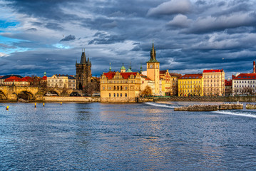 Beautifully illuminated Charles Bridge at sunset with surrounding buildings, Prague