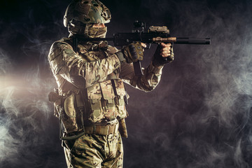 special forces soldier man holding machine gun and military equipment in smoky space