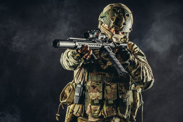 security, soldiers, military forces, defense concept. young russian soldier aiming his gun weapon...
