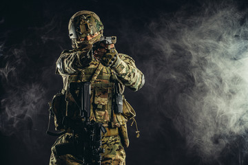 security, soldiers, military forces, defense concept. young russian soldier aiming his gun weapon...