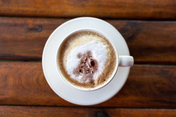 Top view Hot Cappuccino Coffee in a cup on wooden table and Coffee shop