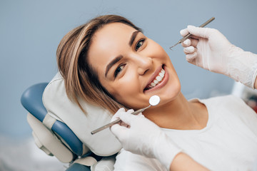 portrait of young caucasian woman with perfect smile in dental office, come to treat spoiled teeth, look at camera - obrazy, fototapety, plakaty