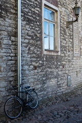 Fototapeta na wymiar Black vintage bike at the stone wall of the old house