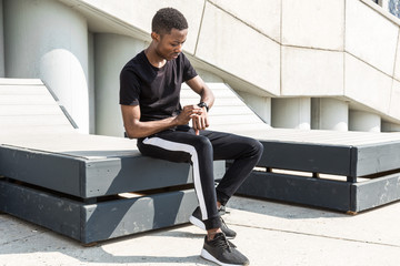 Athletic young afroamerican man running on the promenade. Black Male runner sprinting outdoors. Healthy lifestyle concept.