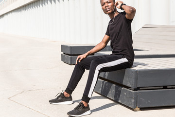 Athletic young afroamerican runner doing warm up on the promenade. Black Male running on outdoors. Healthy lifestyle concept.