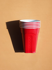 Red plastic cups on a brown background.