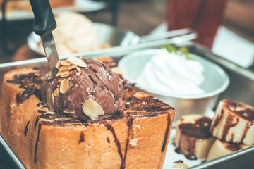 Toast bread with chocolate ice cream in plate on wooden table.