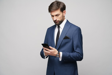 businessman holding phone isolated over grey background