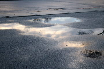 Abstract puddle cloud reflection on street pavement