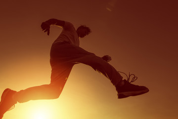 A man running and jump in the air with sunset.