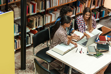 Group of female students study in the college library.Learning and preparing for exam.Educational...