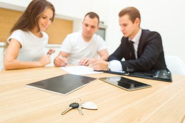 real estate agent is selling an apartment to a young family. conclusion of a lease and purchase of a house, apartment. man shows housing