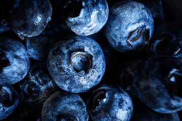 Blueberries close-up. Macro photo. The concept of organic food, vegetarianism, tasty and healthy berries. Dark tones.