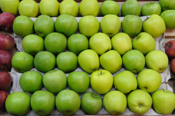 Fresh green, yellow and red apples on shelf in supermarket. Ripe apples of different types.