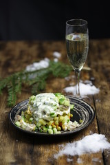 New Year's table. Champagne, Olivier salad, Christmas tree, tangerine and snow.