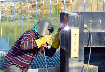 The welder working to welding the bushing of stoplock sluice the dam,December 2019