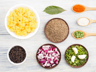 Fototapeta na wymiar Ingredients for cooking pasta: garlic, black pepper, onion, green herb, bay leaves, red chili pepper, salt, cumin (jeera). Healthy eating concept