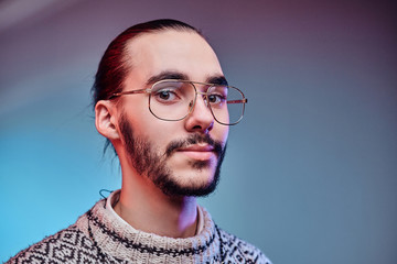 Handsome man in glasses is posing for photographer at studio.