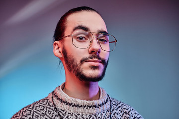 Handsome man in glasses is posing for photographer at studio.